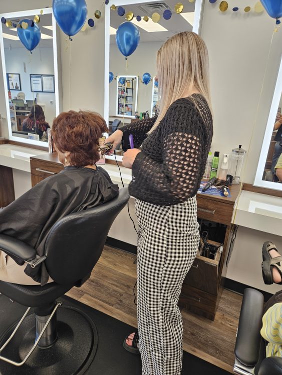 Stylist providing Guest with service at salon station.